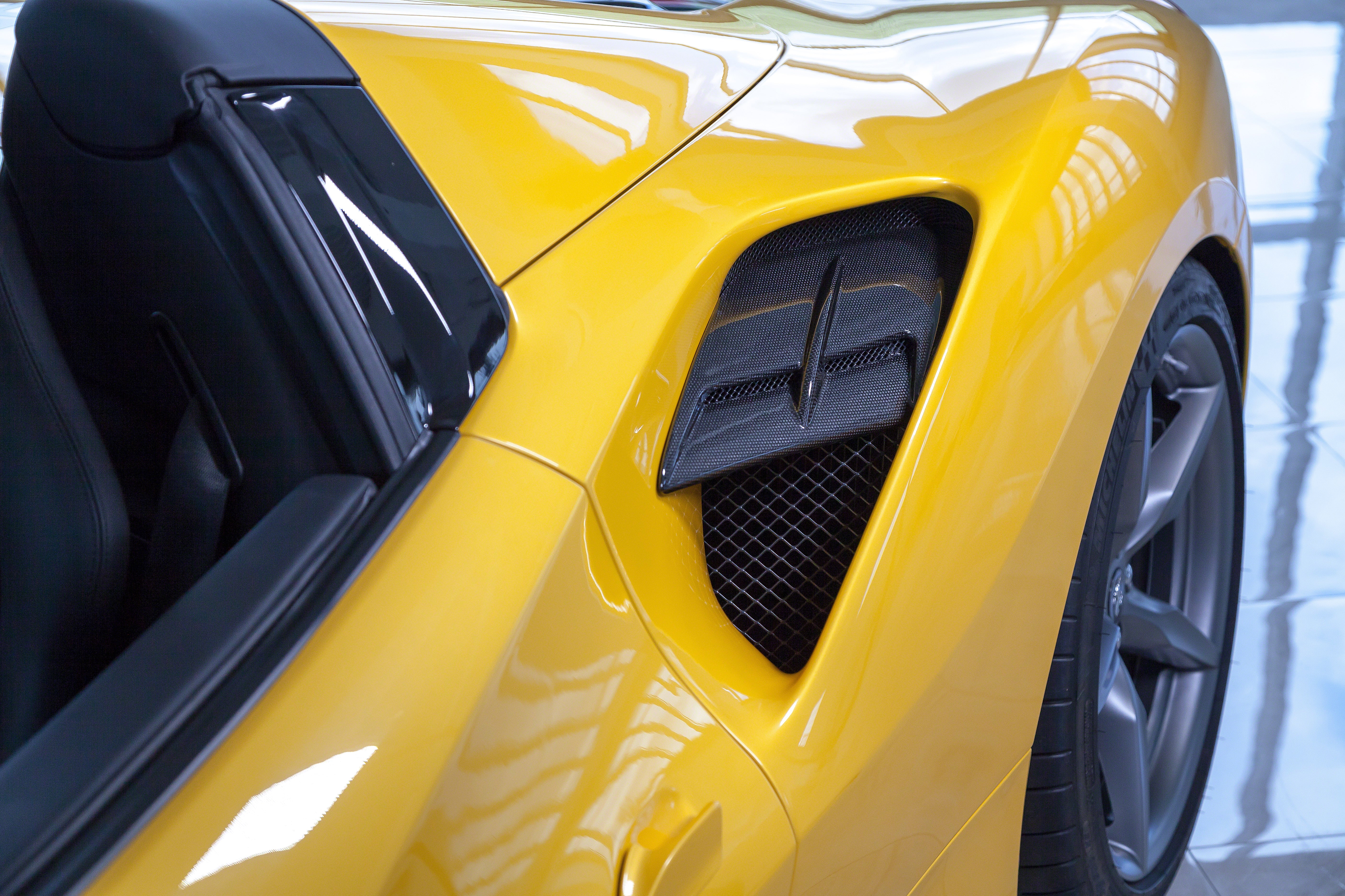 Capristo carbon fiber side air intake panel on a yellow Ferrari 488 Spider