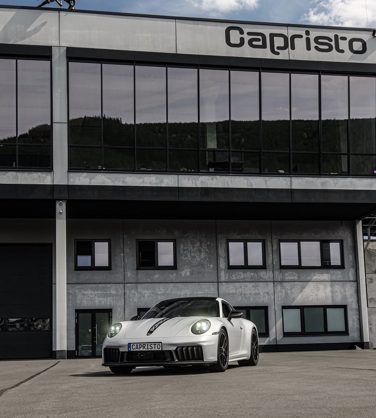 White Porsche 911 Carrera GTS 992.2 parked in front of the Capristo factory in Germany