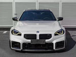 A front wide view of AUTOTECKNIC DRY CARBON PERFORMANTE FRONT LIP - BMW G87 M2 2023+ fitted on a car
