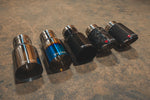 A side view of a five different styles of Valvetronic Designs Exhaust Tips on the ground.