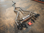 A side overview of Valvetronic Designs Valved Sport Exhaust System with wires and a small red box on the ground (for BMW F87 M2).