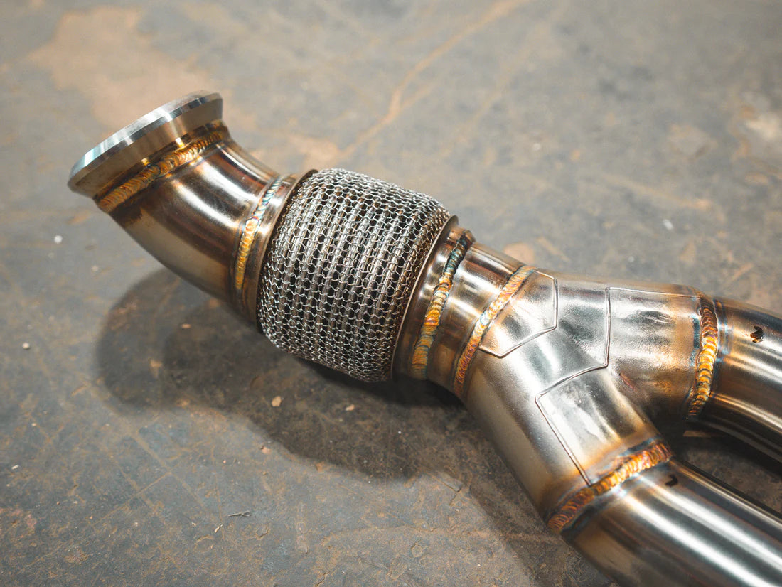 A close view of a part of Valvetronic Designs Valved Sport Exhaust System on the ground (for BMW F87 M2).