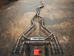 A top view of Valvetronic Designs Valved Sport Exhaust System with wires and a small red box on the ground (for BMW F87 M2).