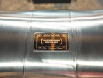 A close up view of Valvetronic Designs Valved Sport Exhaust System's muffler, showing the brand's logo (for BMW G20/G22 M340i/M440i).