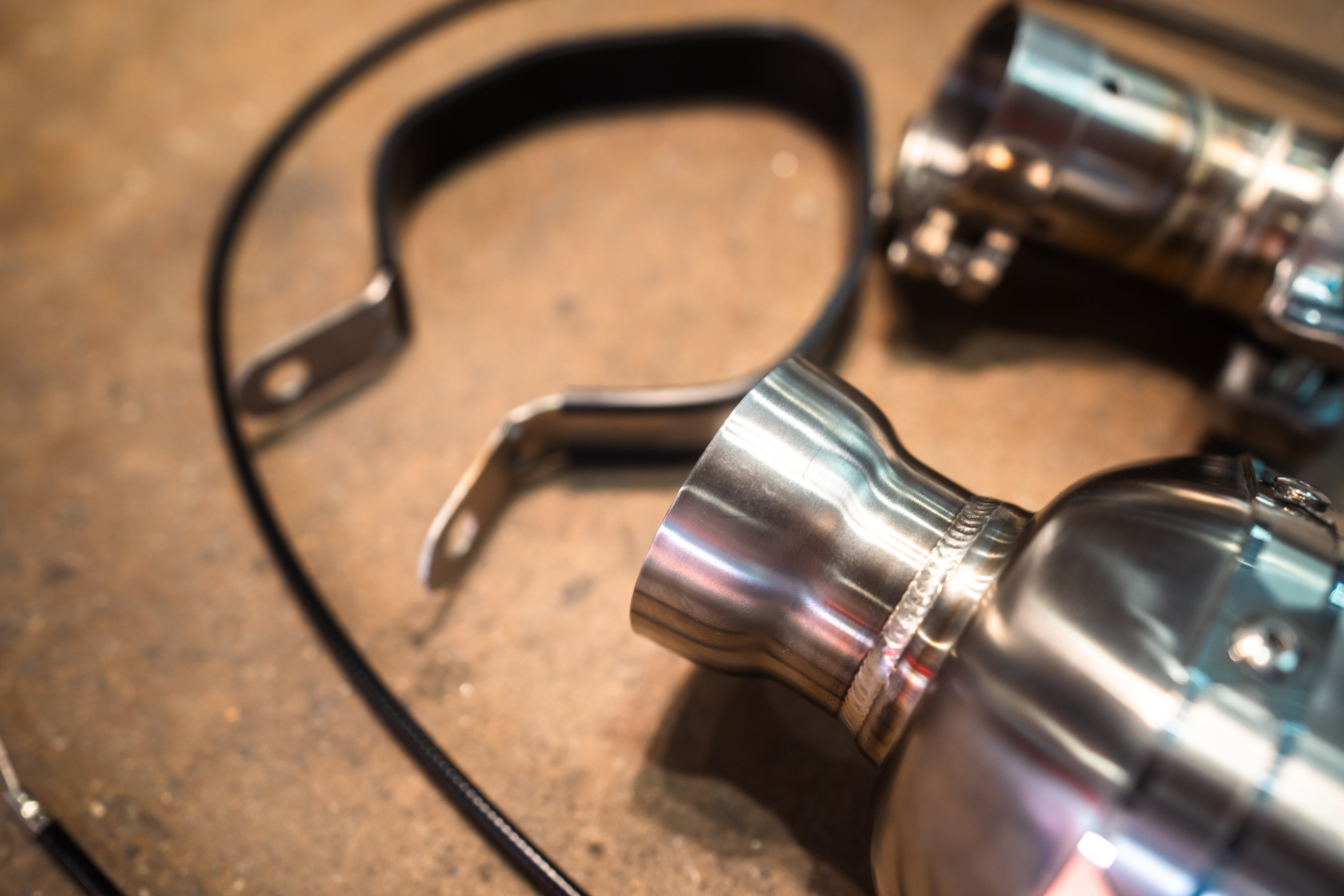 Valvetronic Designs Motorcycle Valved Muffler manufacturer gallery: muffler inlet and black mounting strap