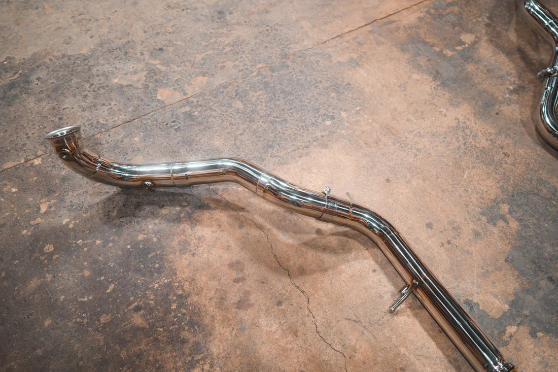 A wide view of Valvetronic Designs Valved Sport Exhaust System's free flow bypass pipes on the ground (for Mercedes Benz G-Wagon G550, G63 / Squared).