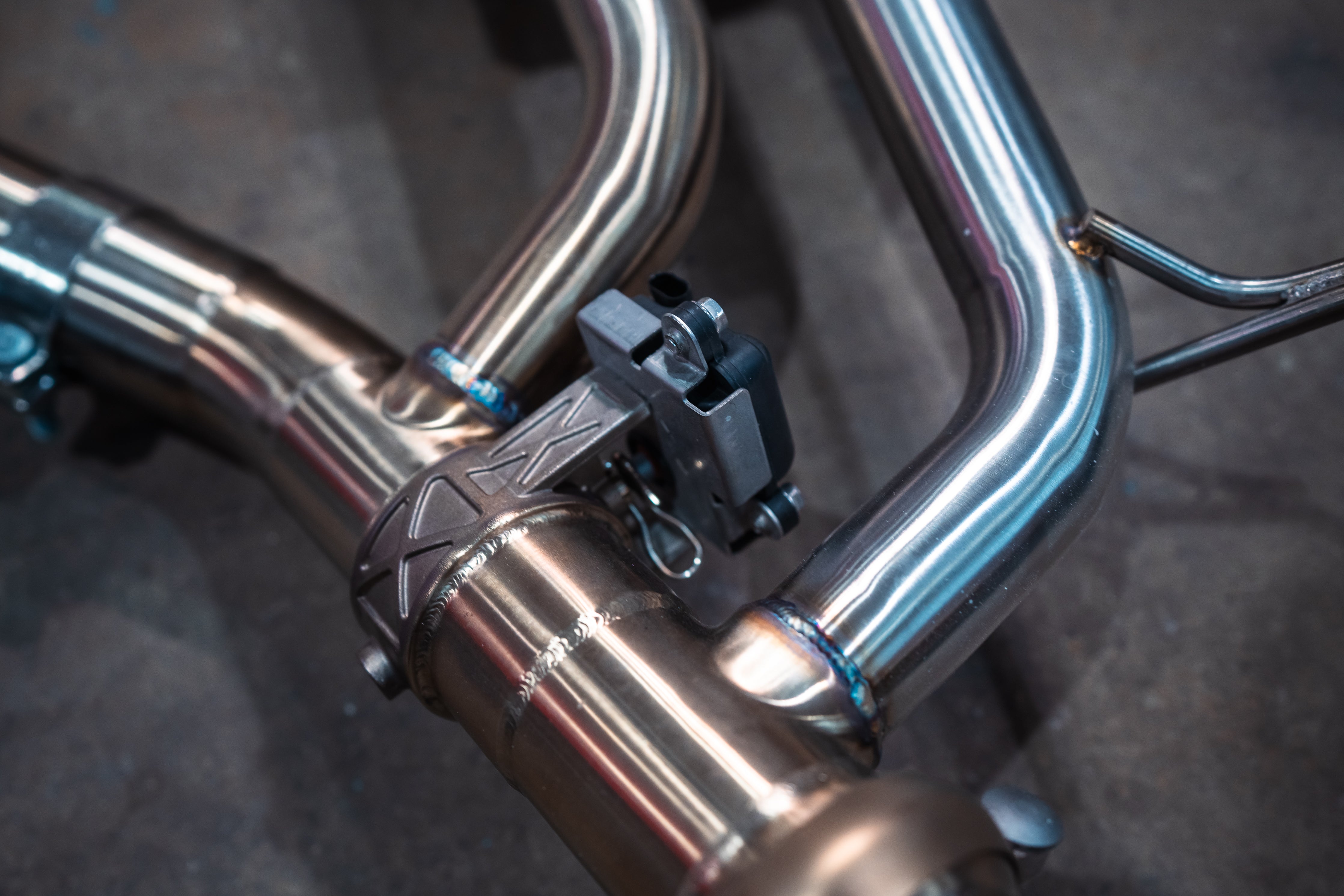 Stainless exhaust BMW X7 40i: electronic actuator beside muffler