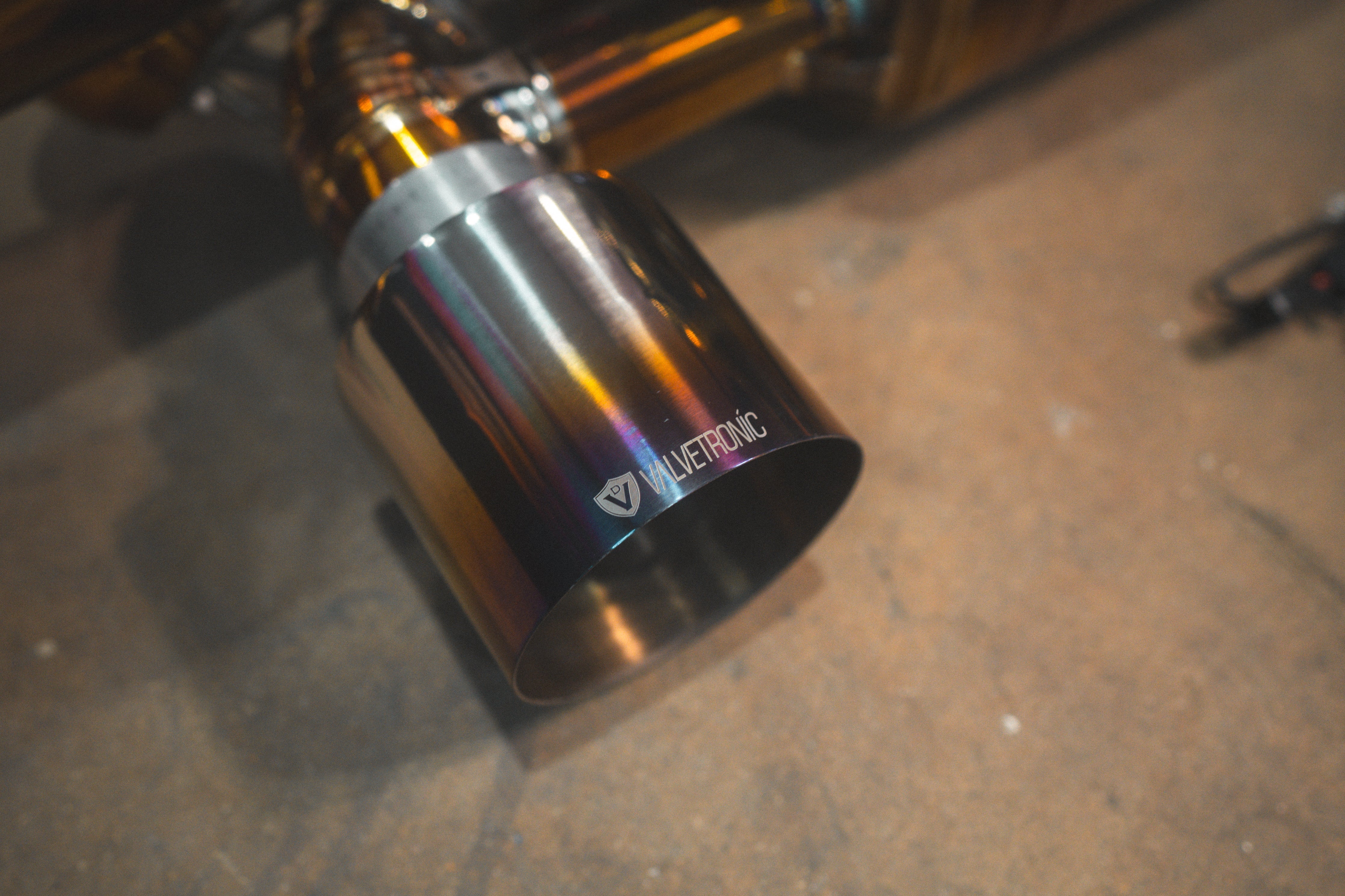 Valvetronic Designs Rear Exhaust Porsche 718 GT4 RS manufacturer gallery: single gold-and-blue-toned outlet tip with branding