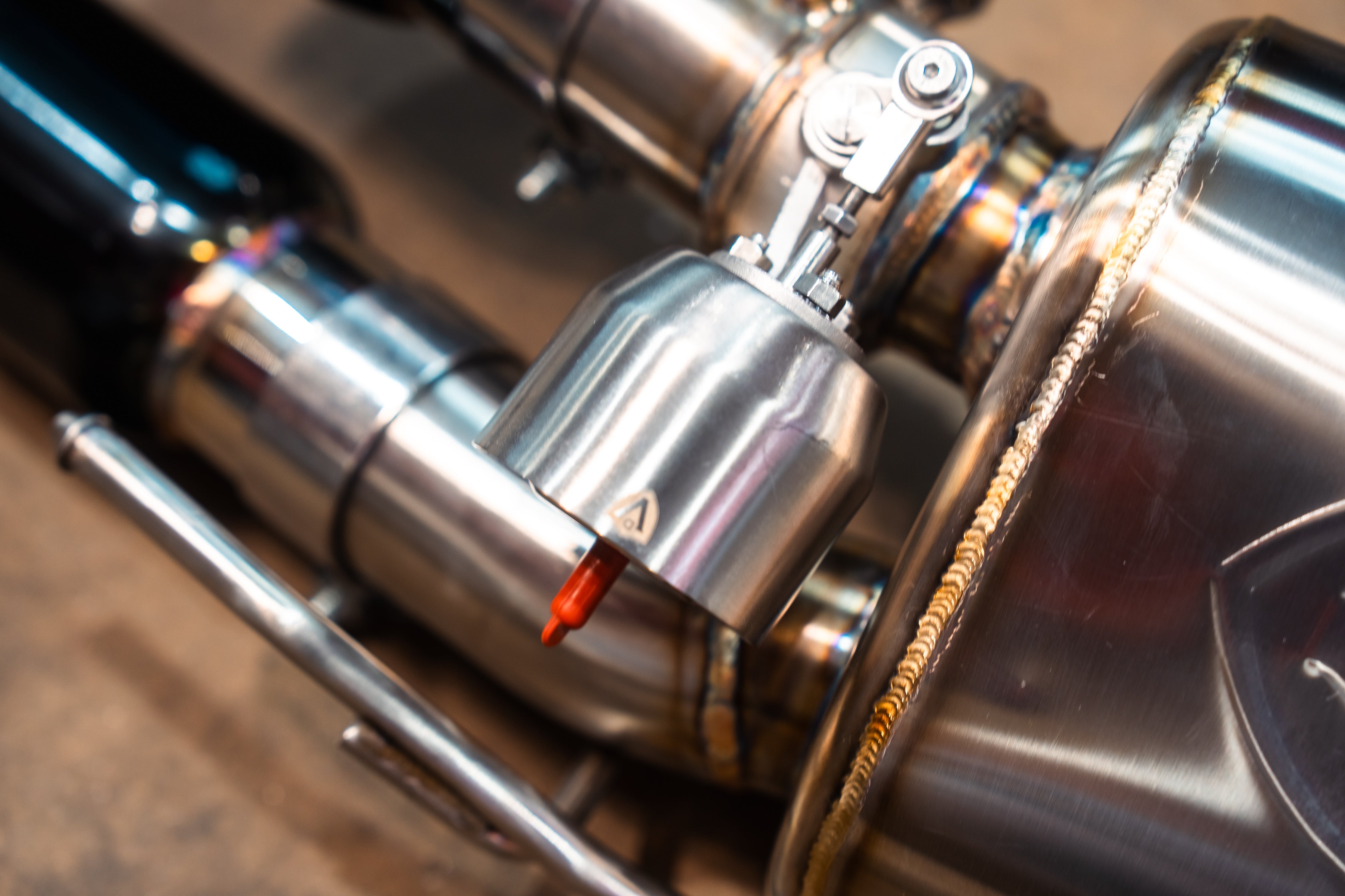 Valvetronic Designs Valved Exhaust Lexus RC F manufacturer gallery: silver valve actuator beside the rear muffler