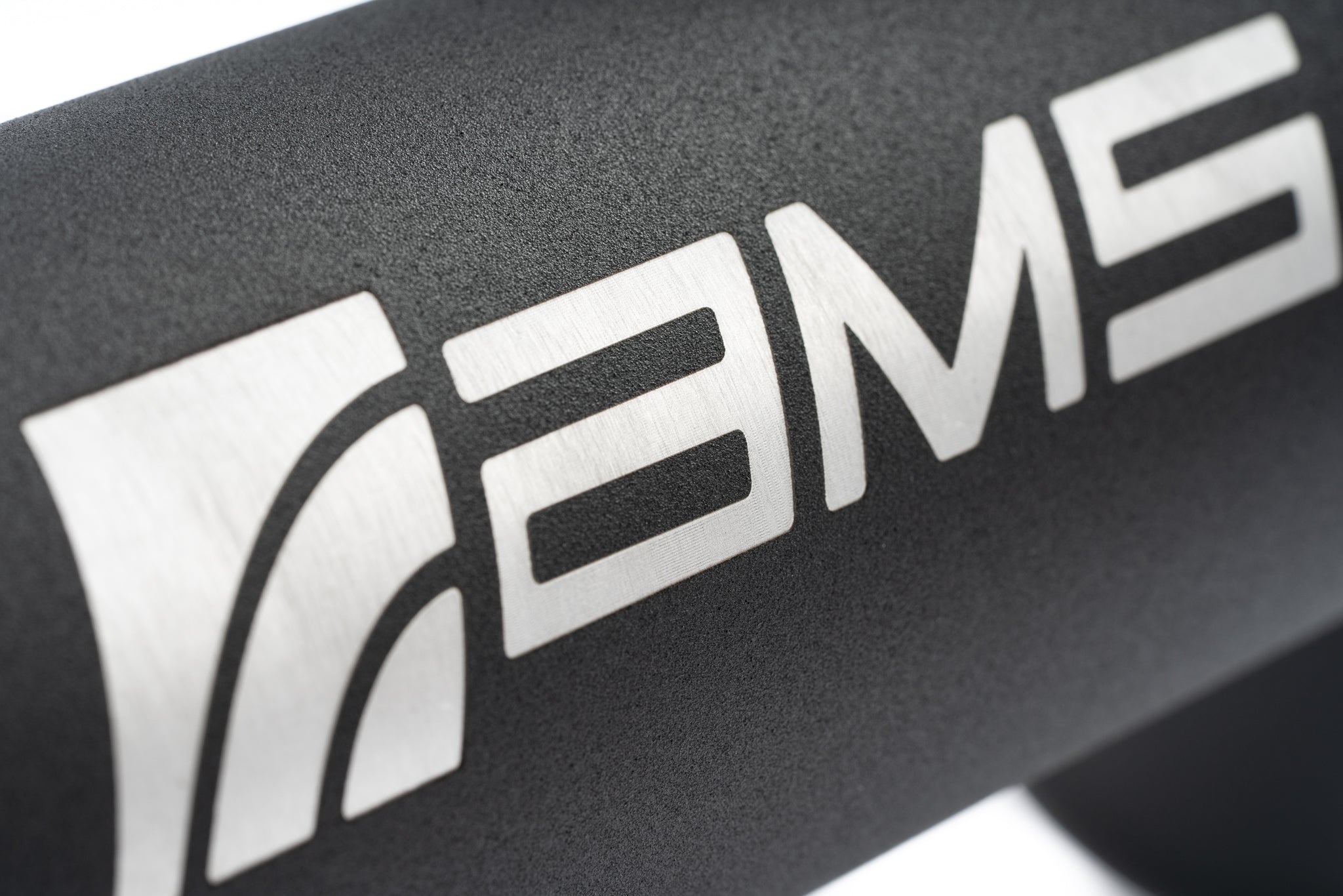 Close up of the AMS logo on a black powder coated F150 intercooler pipe