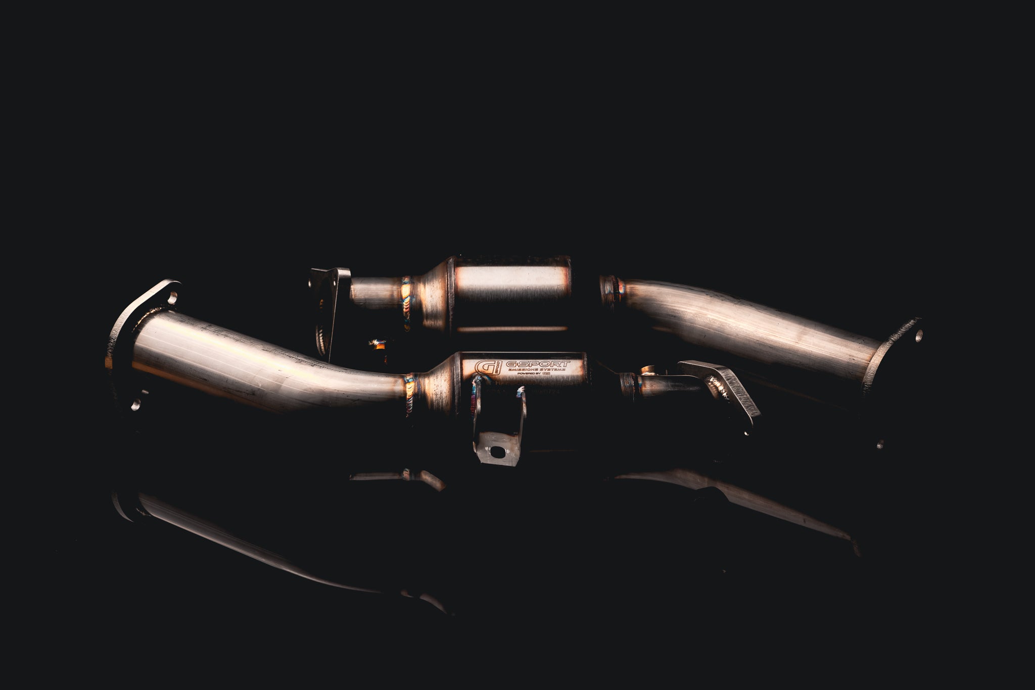 AMS street lower downpipes for the Infiniti Q50 and Q60 laid out on a dark background