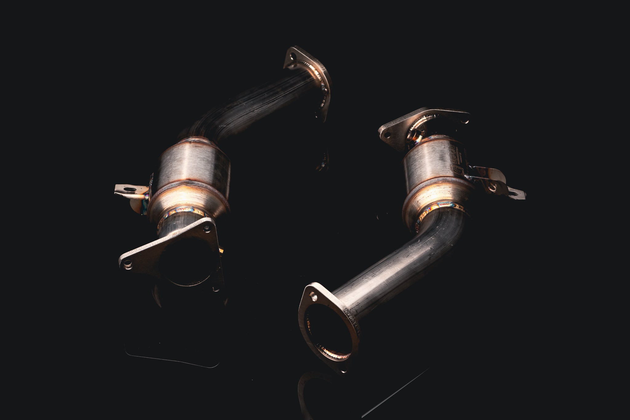 Both AMS catted lower downpipes from above, showing the inlet flanges and GESI converter bodies