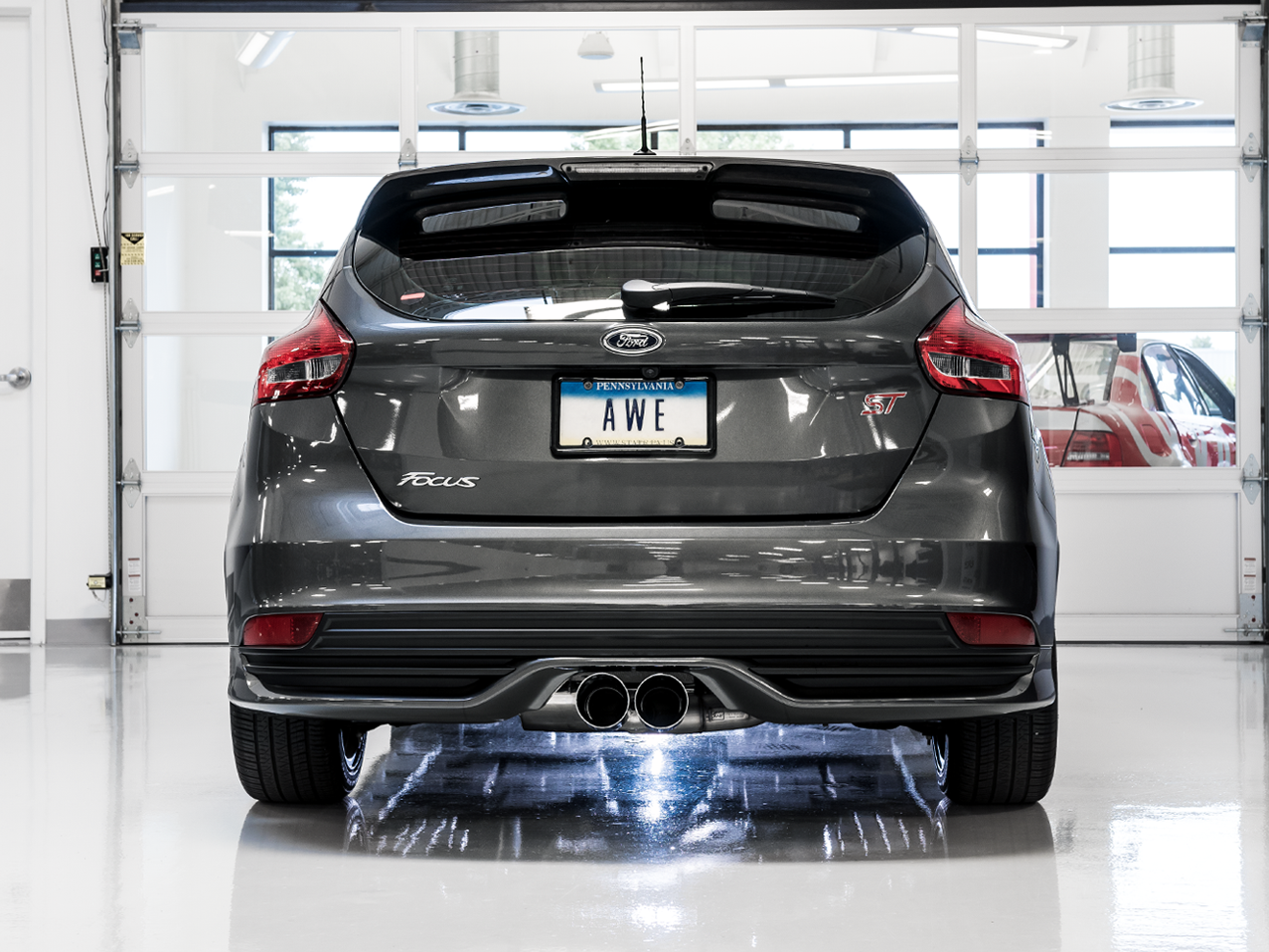 Rear view of a gray Mk3 Focus ST in a white garage with AWE twin Chrome Silver center tips