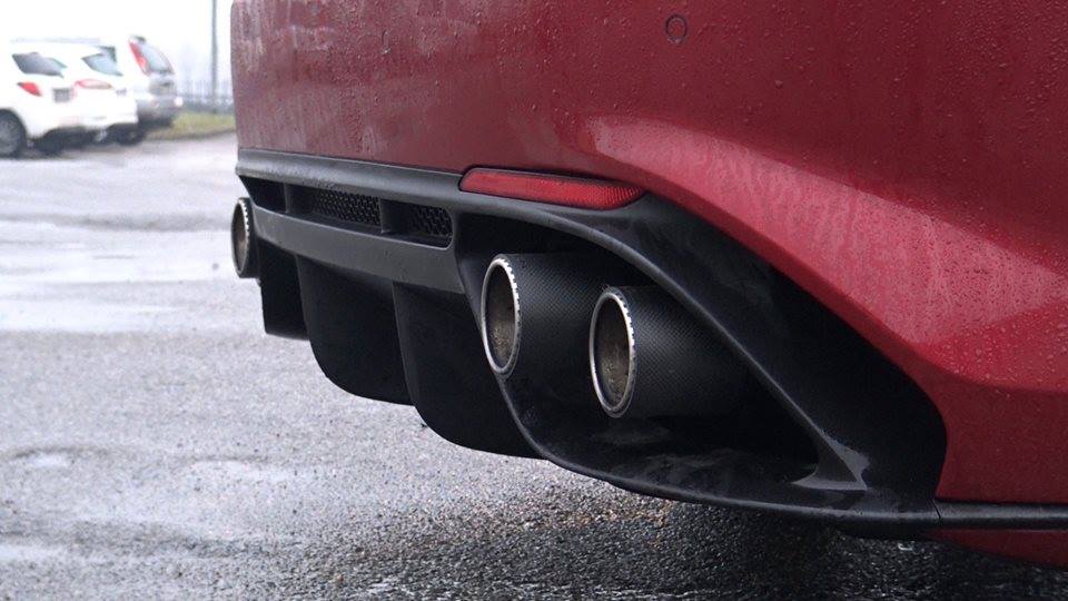 Capristo carbon twin tips in the diffuser of a red Giulia Quadrifoglio