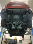 Red Giulia Quadrifoglio on a lift showing Capristo connecting pipes from below