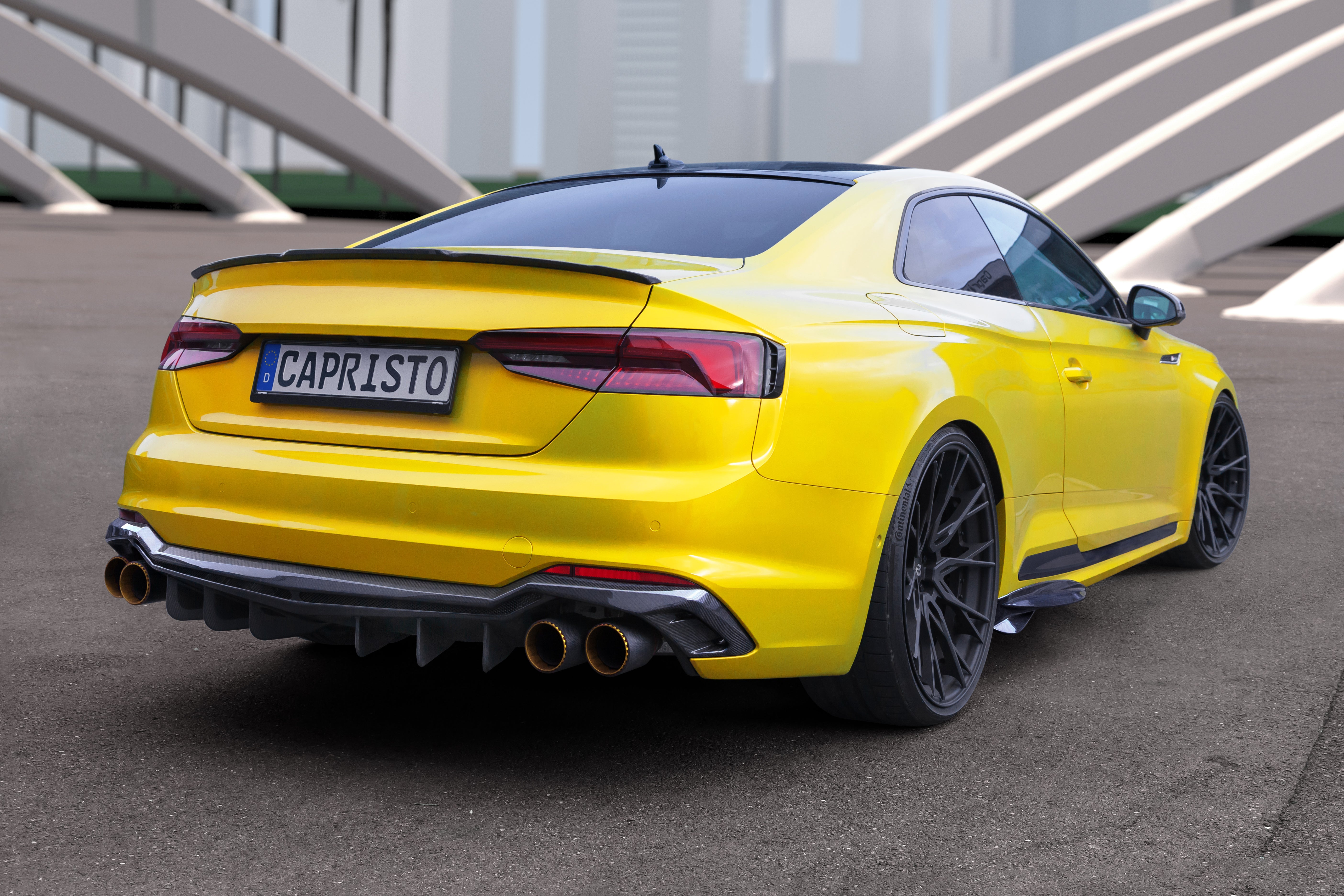 Yellow Audi RS5 coupe rear three-quarter showing Capristo carbon diffuser