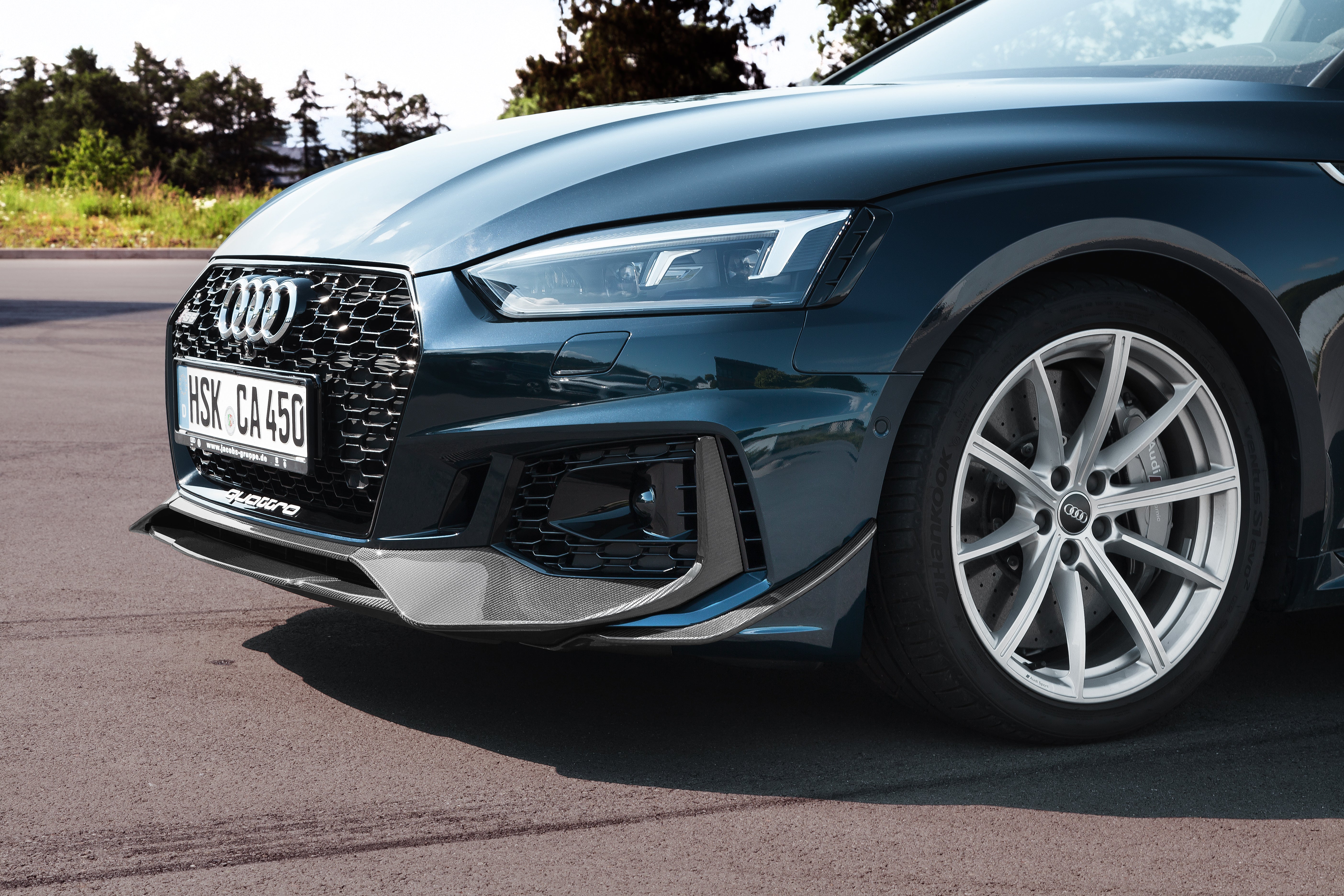 Dark green Audi RS5 front three-quarter with Capristo carbon fiber front spoiler