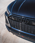 Urban carbon front splitter under the bumper of a blue Audi RS6 Avant C8, close-up