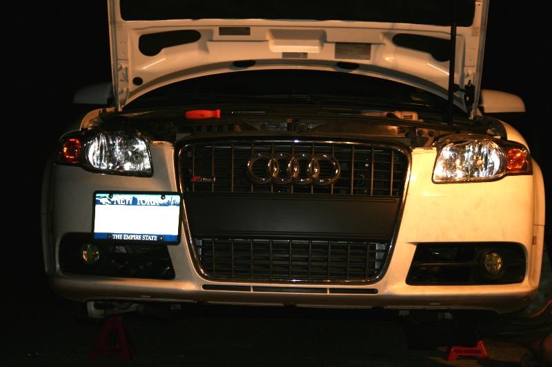 A front view of stealthy type III hard anodized black Evolution Racewerks Audi A4 (B7) Competition Series Front Mount Intercooler (FMIC) Kit installed in a car 