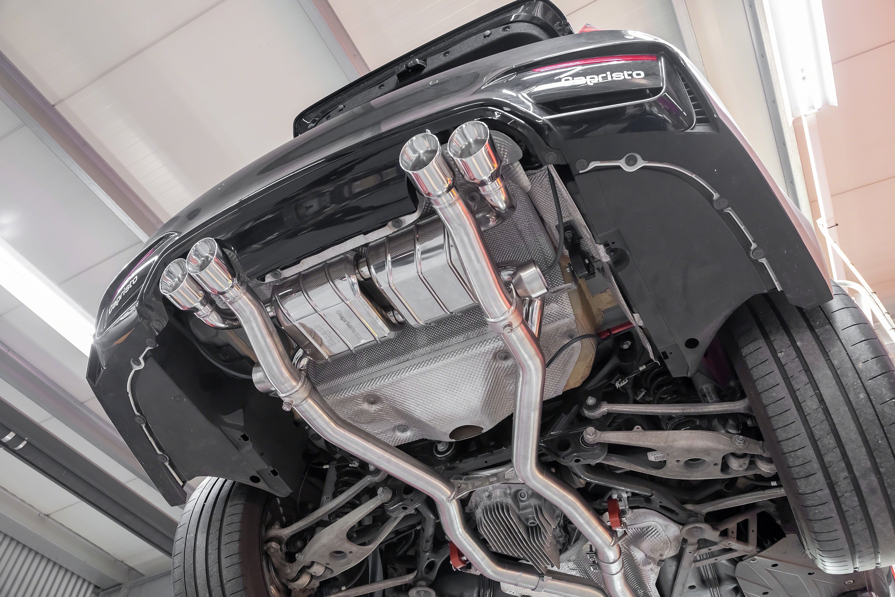 Capristo M3/M4 valved exhaust installed under a BMW M4, view from below