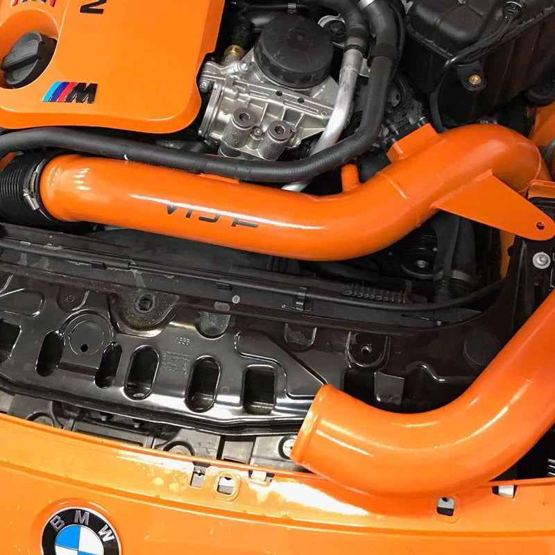 Close view of the VRSF front facing intake pipes running beside the S55 engine in an orange M3