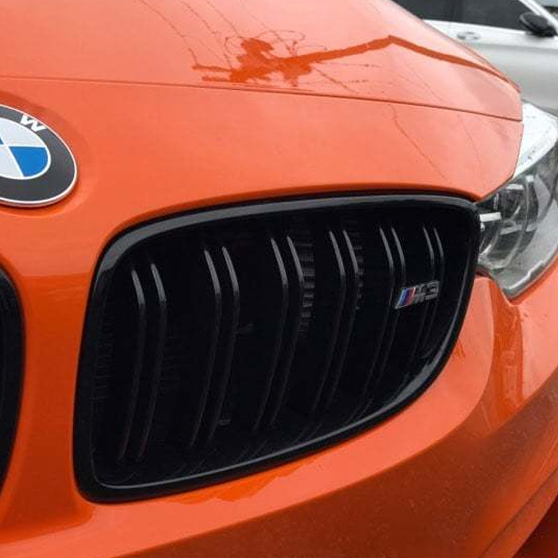 Front grille of an orange F80 M3 that hides the VRSF front facing intake filters