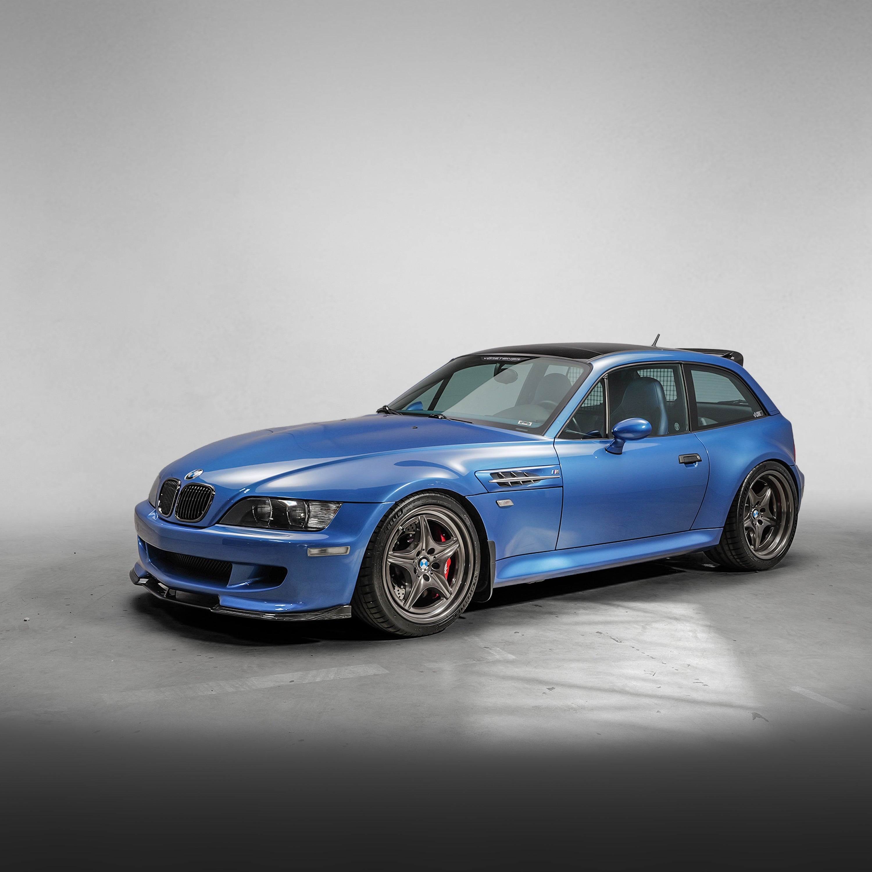 Blue M Coupe with roof spoiler, front 3/4 view