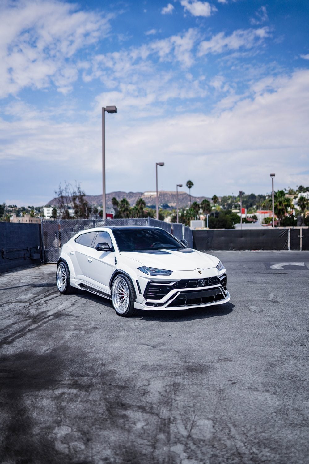 White Lamborghini Urus front three-quarter with the complete aero kit in a parking lot