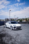 White Lamborghini Urus front three-quarter with the complete aero kit in a parking lot
