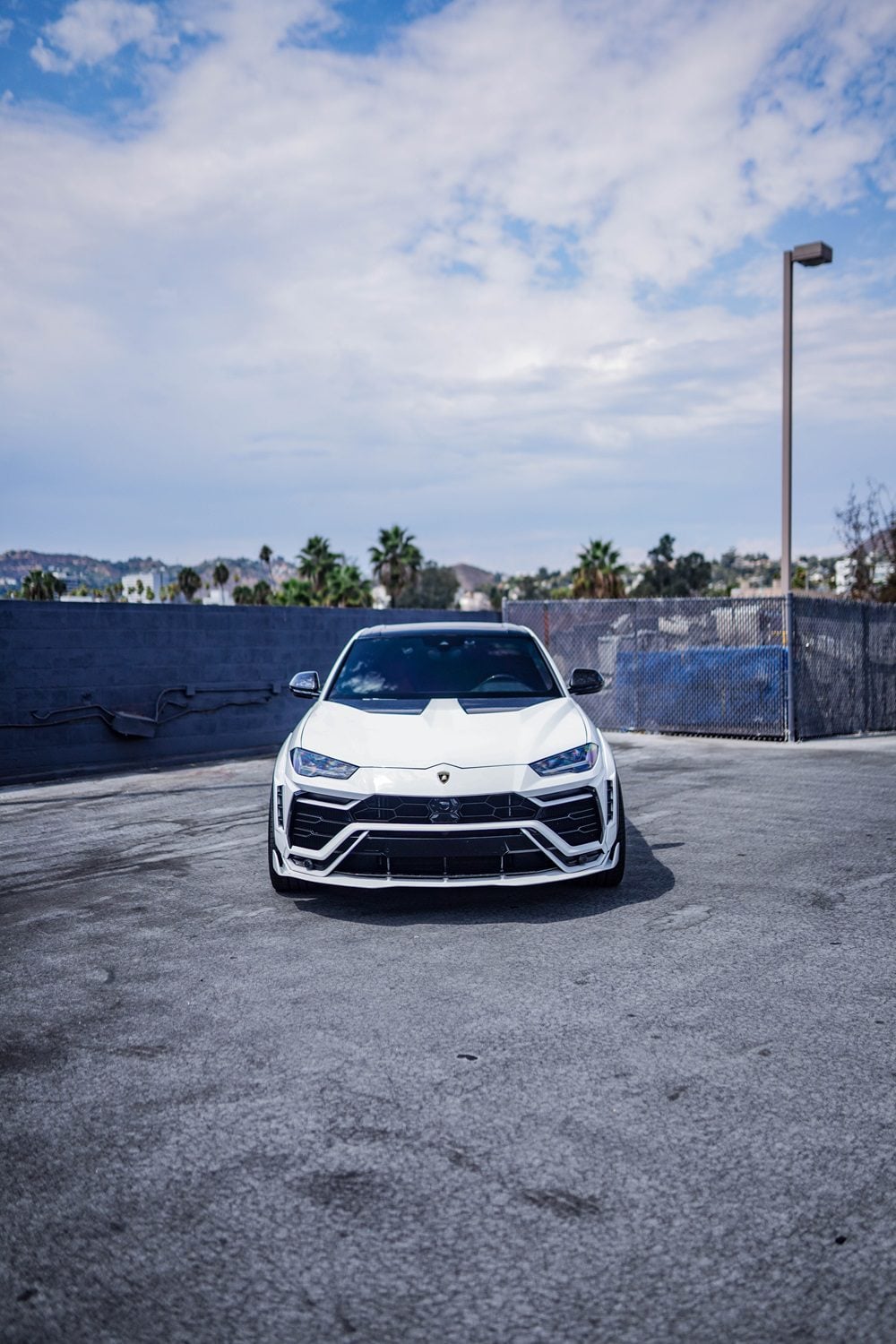 White Lamborghini Urus front view with the complete aero kit in a parking lot