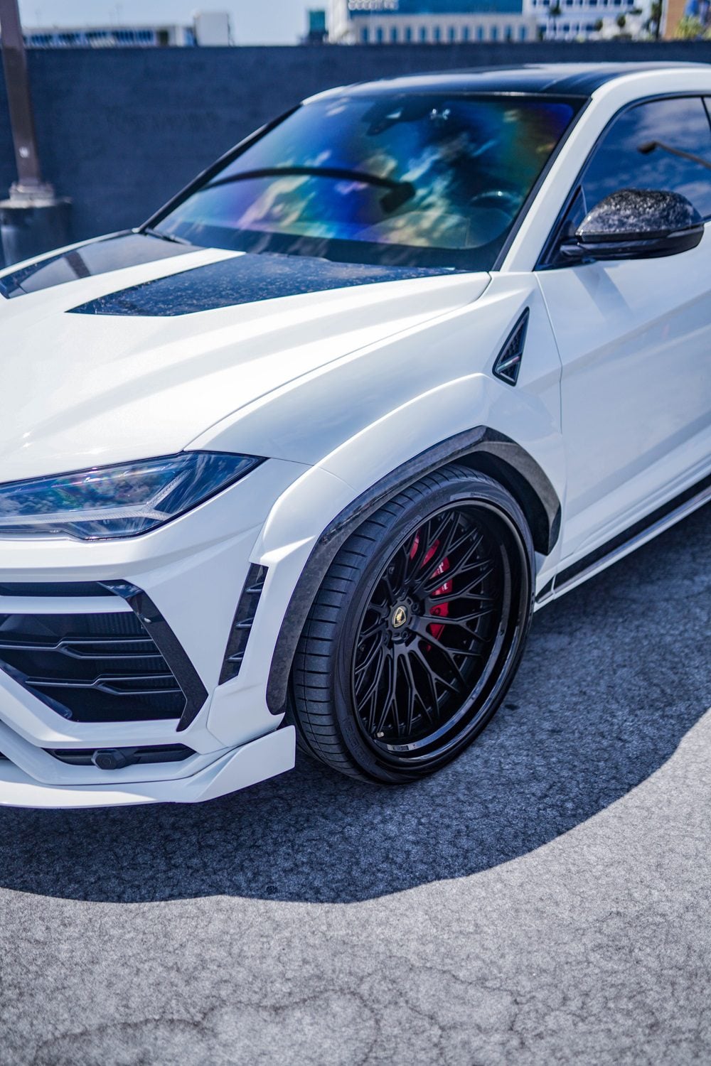 White Urus with carbon fender arches and hood vents