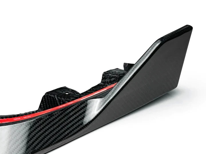 A close up view of AUTOTECKNIC PERFORMANCE DRY CARBON FRONT LIP SET - BMW F95 X5M 2019+ with white background