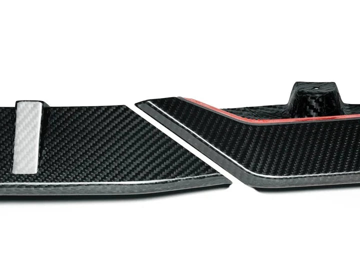 A close up view of AUTOTECKNIC PERFORMANCE DRY CARBON FRONT LIP SET - BMW F95 X5M 2019+ with white background
