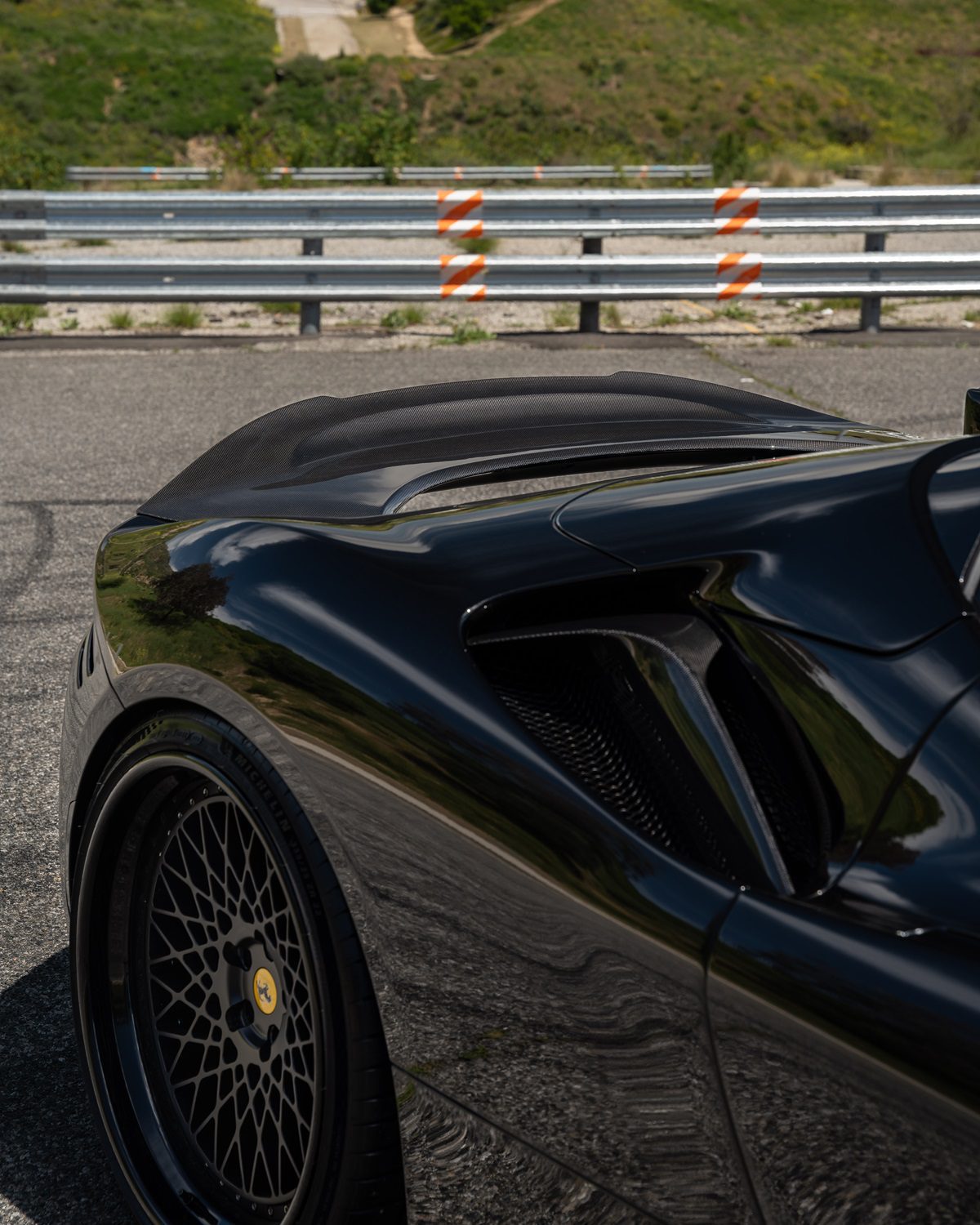 Race spoiler on a black Ferrari SF90, side close-up