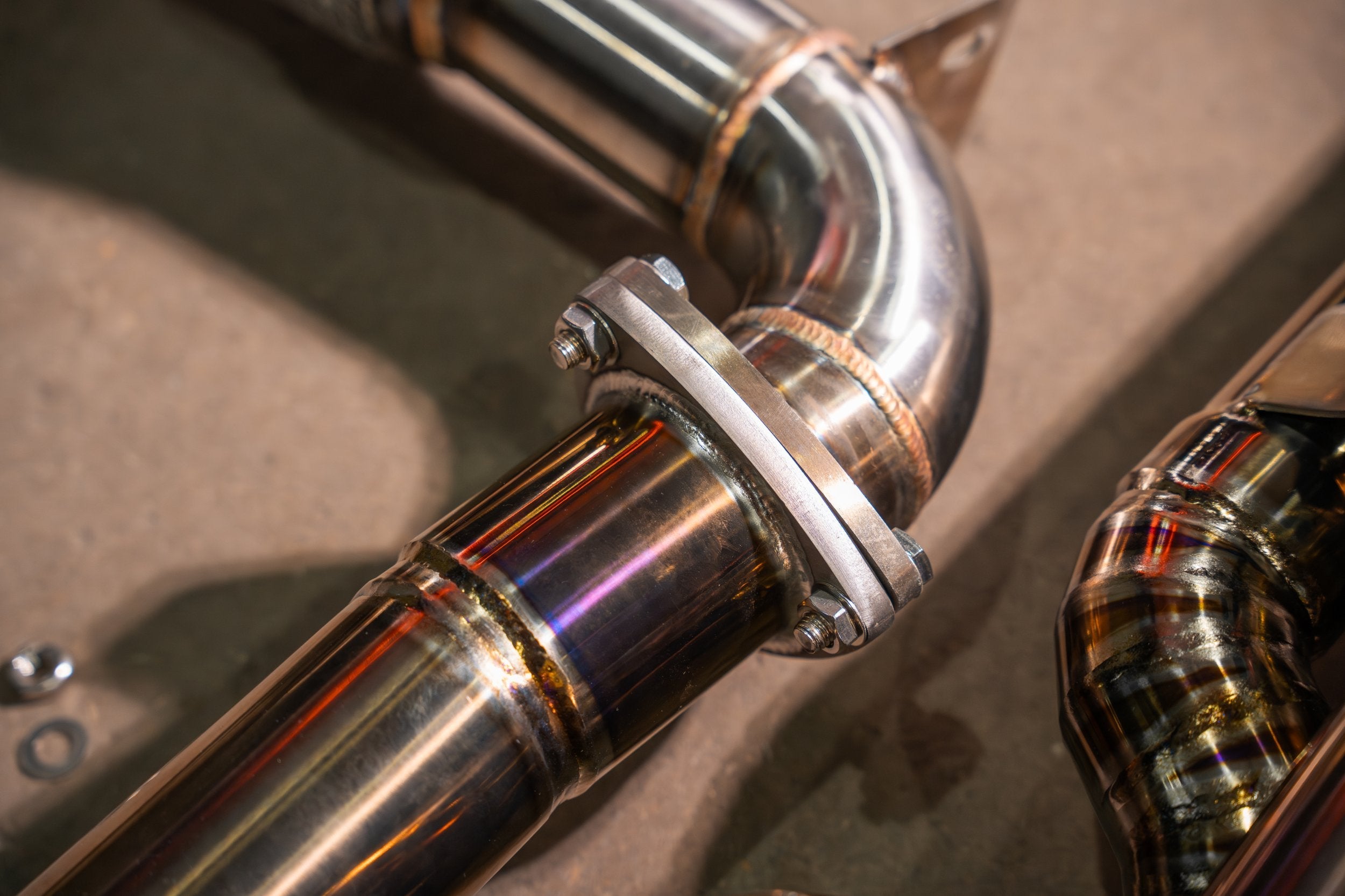 Valvetronic Designs Valved Exhaust Lotus Emira manufacturer gallery: clamp around a curved polished tube beside the muffler