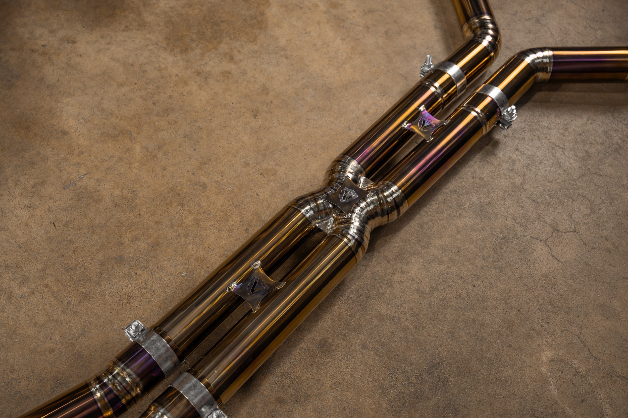 Valvetronic Designs Valved Exhaust BMW G90 M5 manufacturer gallery: mid-pipe crossover and welded joints viewed diagonally