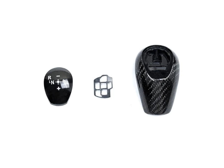 A top view of AUTOTECKNIC CARBON FIBER GEAR SELECTOR COVER - BMW E9X M3 2007-2013 with white background