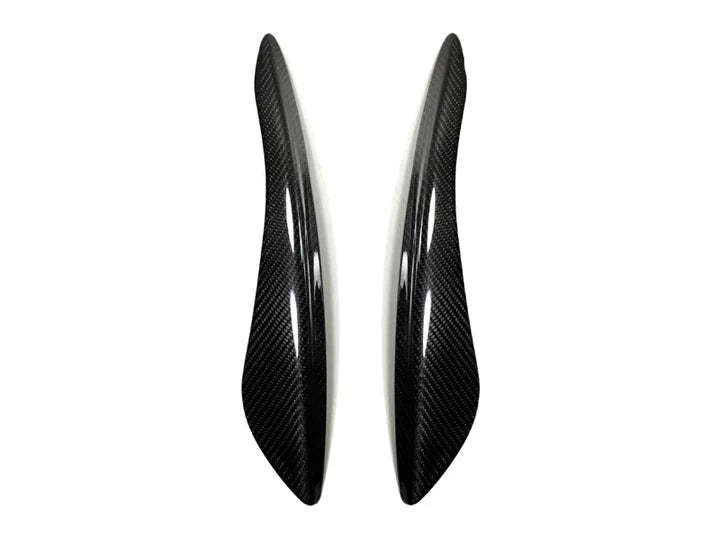 A front view of AUTOTECKNIC CARBON FIBER HEADLIGHT COVERS - INFINITI G35 COUPE 2003-2007 with white background