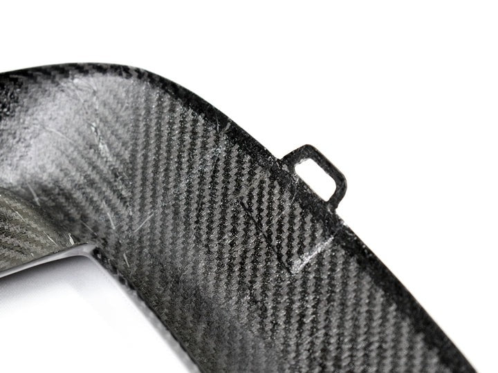 A close up view of AUTOTECKNIC PERFORMANCE DRY CARBON BUMPER TRIM SET - BMW F9X M8 2019+ with white background