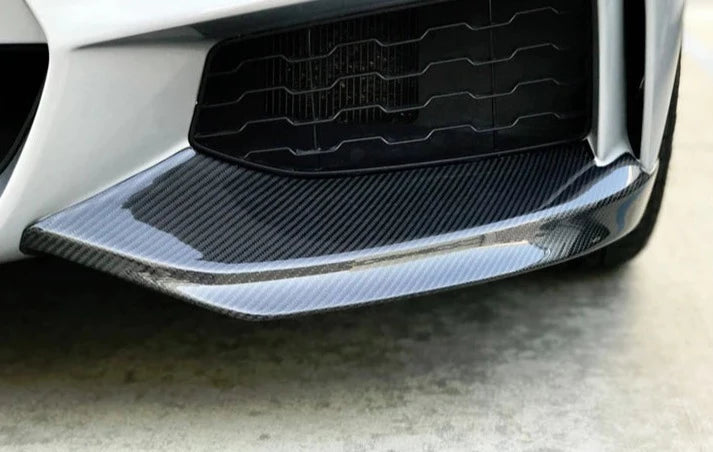 A close up view of AUTOTECKNIC VACUUMED CARBON FIBER AERO SPLITTERS - BMW F32/ F33/ F36 4-SERIES M-SPORT 2014-2020 fitted on a car
