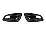 A front view of AUTOTECKNIC DRY CARBON INTERIOR DOOR HANDLE TRIM SET - BMW E82 1M | E81 / E87 / E88 1-SERIES 2007-2013 with white background