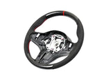 A front view of AUTOTECKNIC REPLACEMENT CARBON STEERING WHEEL - BMW F91/ F92/ F93 M8 2019+ with white background