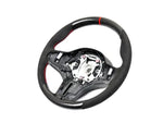 A front view of AUTOTECKNIC REPLACEMENT CARBON STEERING WHEEL - BMW F91/ F92/ F93 M8 2019+ with white background