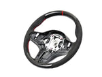 A front view of AUTOTECKNIC REPLACEMENT CARBON STEERING WHEEL - BMW F91/ F92/ F93 M8 2019+ with white background