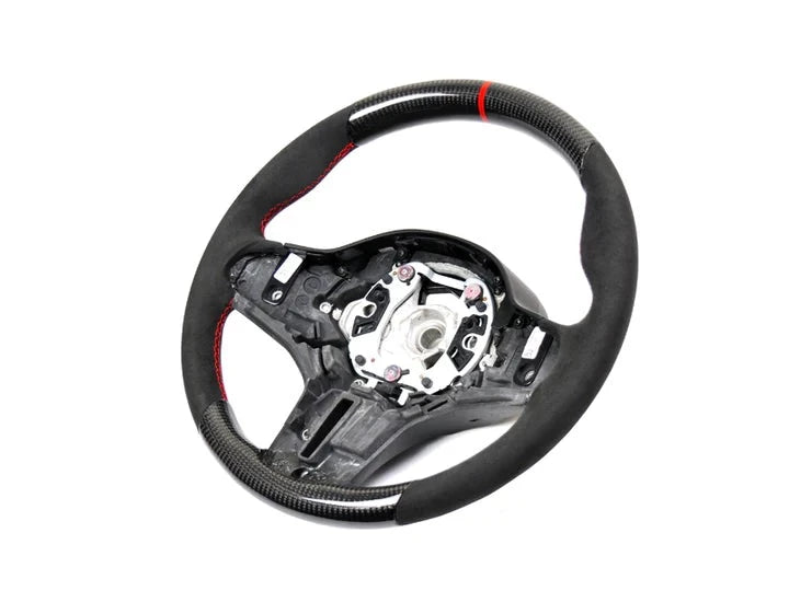 A front view of AUTOTECKNIC REPLACEMENT CARBON STEERING WHEEL - BMW F90 M5 2018+ with white background