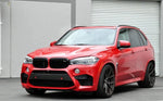 A side wide view of a red car fitted with AUTOTECKNIC DRY CARBON FIBER BUMPER TRIM - BMW F85 X5M | F86 X6M 2015-2021