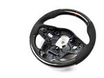 A front view of AUTOTECKNIC REPLACEMENT CARBON STEERING WHEEL - TOYOTA A90 SUPRA 2020+ with white background