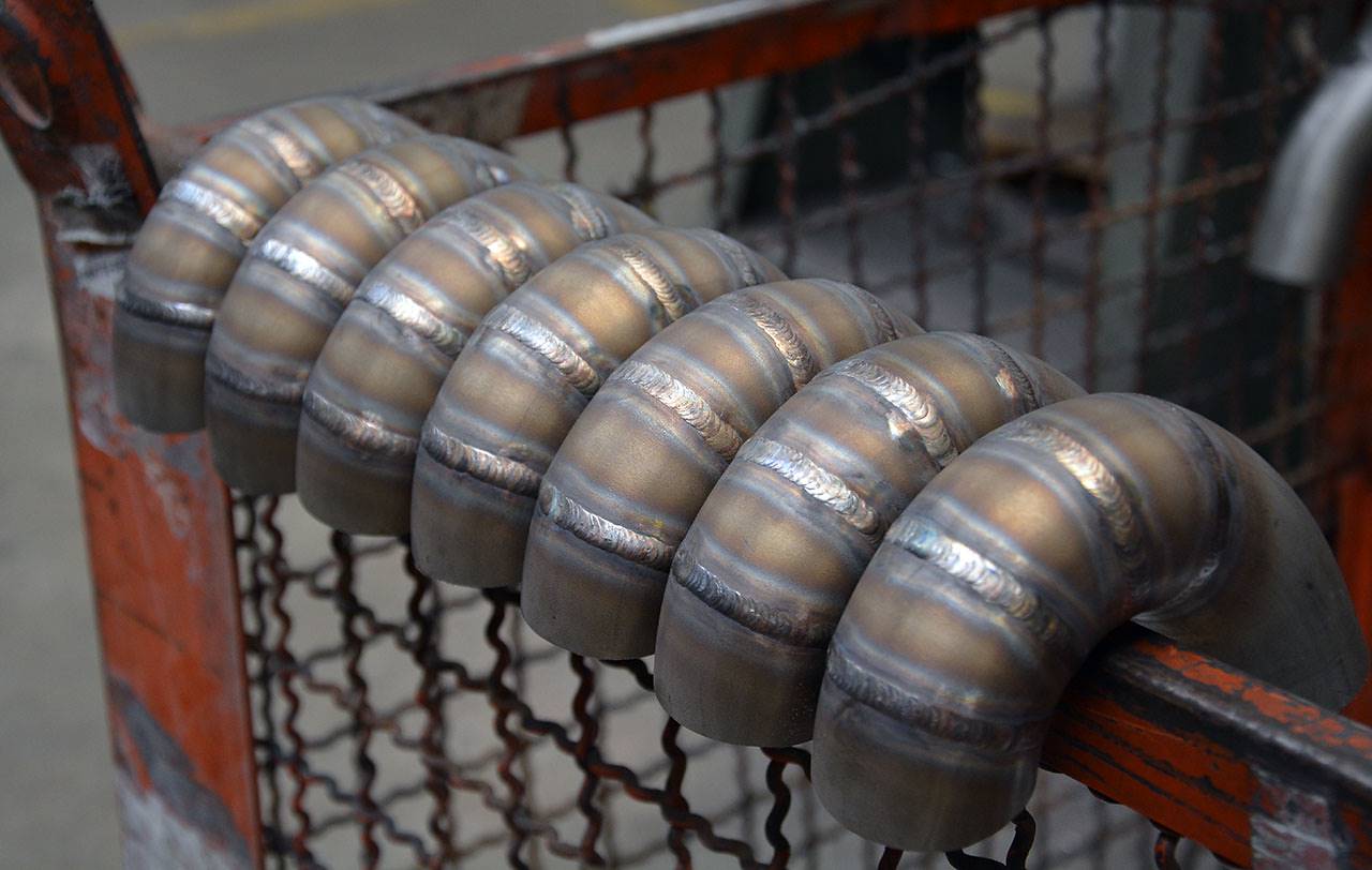 wide view of Supersprint Manifold 100% Stainless steel "Step Design" (Left Hand Drive) for BMW E36 All models 1990-2000 displayed on a fence