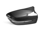 A close up view of one of the AUTOTECKNIC REPLACEMENT DRY CARBON MIRROR COVERS - BMW F9X M8 2019+ with white background