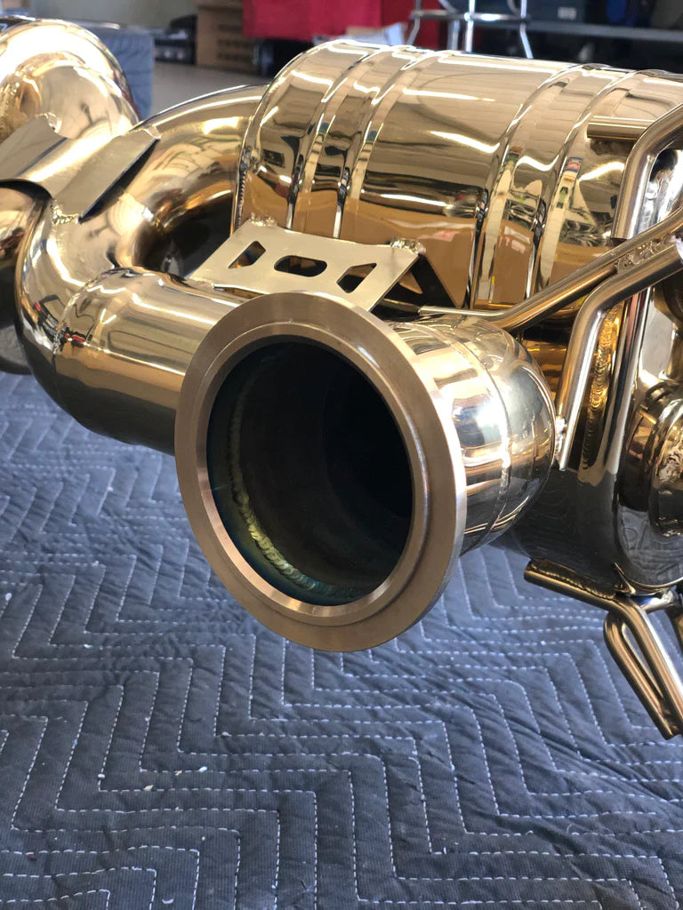 A close up of a part of Valvetronic Designs Valved Sport Exhaust System (for Audi R8 V8 / V10)  on a black rug on the ground.